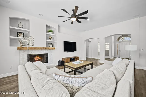 a living room with furniture a flat screen tv and a fireplace