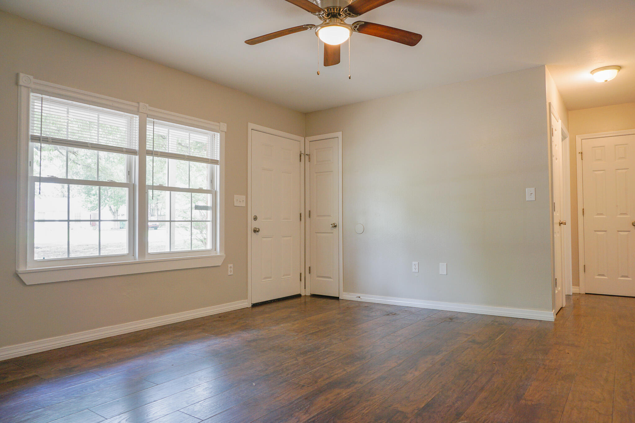 6115 Willow Lane North Crestview, FL 32539 - Photo 7 of 29 an empty room with wooden floor chandelier fan and windows