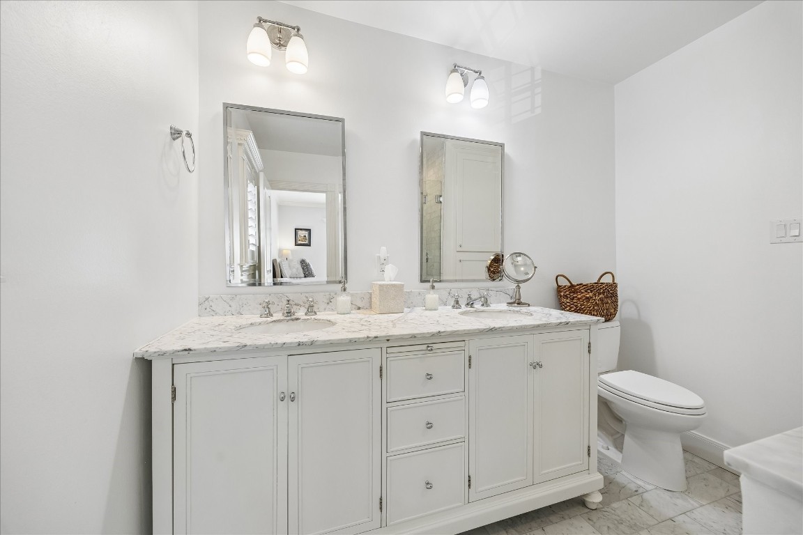 1741 Banks Street Houston, TX 77098 - Photo 14 of 31 a bathroom with a granite countertop toilet a sink and a mirror