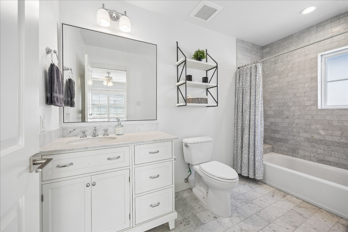 1741 Banks Street Houston, TX 77098 - Photo 18 of 31 a bathroom with a granite countertop toilet sink and mirror