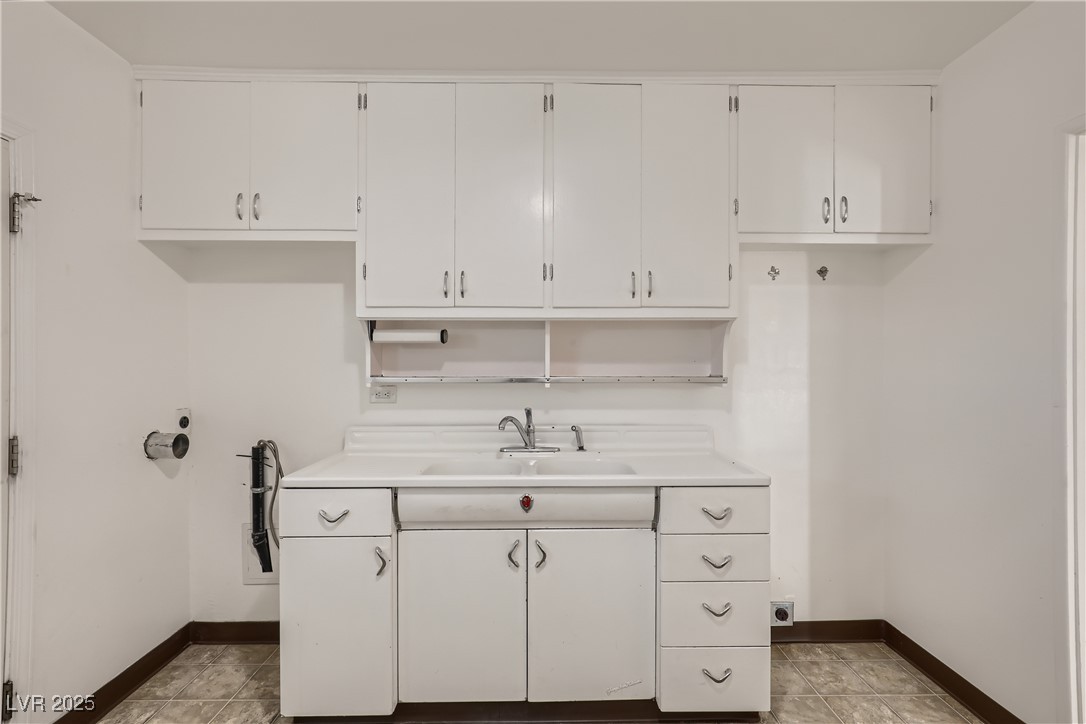 103 West Victory Road Henderson, NV 89015 - Photo 12 of 28 Kitchen with a sink, baseboards, and white cabinets