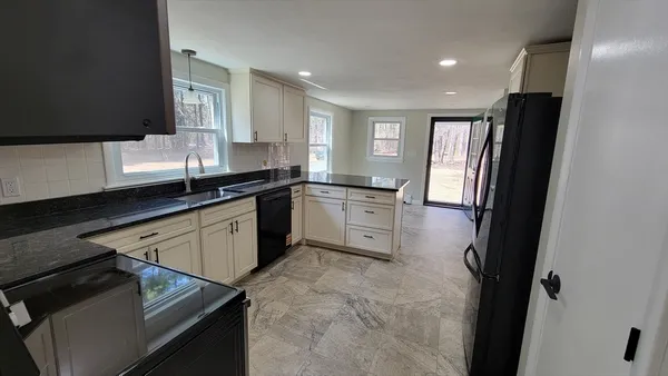 a kitchen with stainless steel appliances granite countertop a sink stove and refrigerator