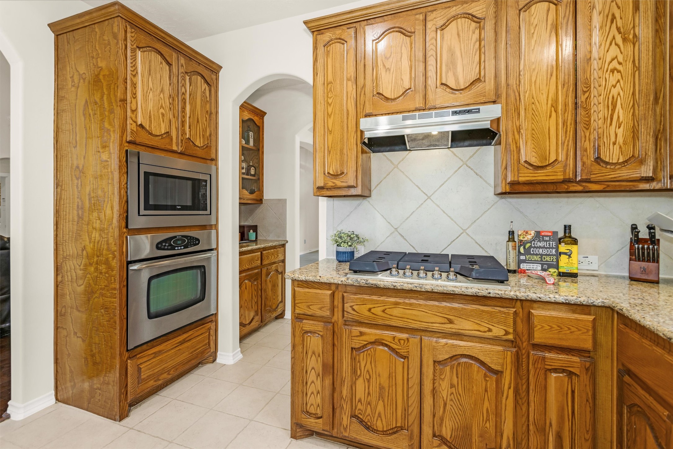 3211 Burton Ridge Drive Spring, TX 77386 - Photo 19 of 49 a kitchen with stainless steel appliances granite countertop a stove and a microwave
