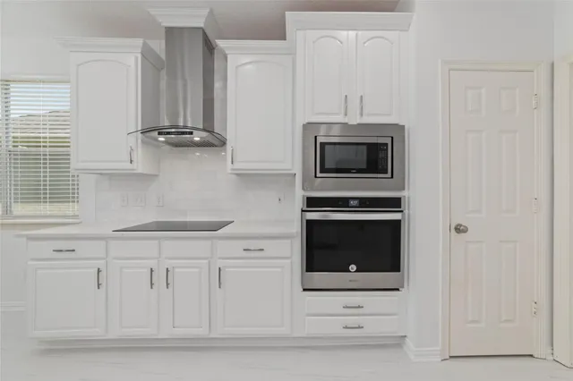 a kitchen with white cabinets and stainless steel appliances