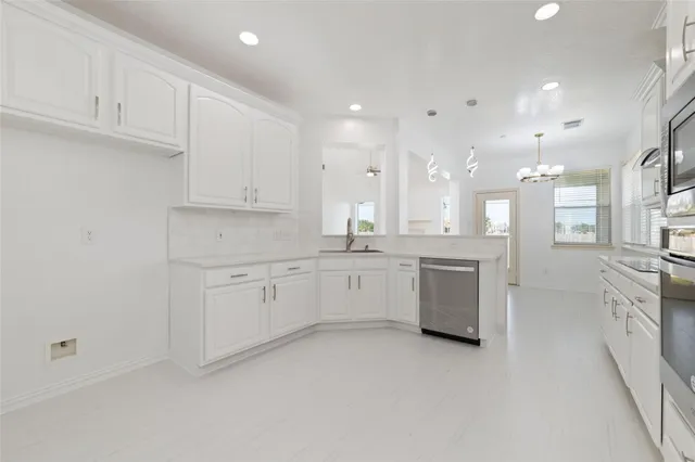a large white kitchen with cabinets