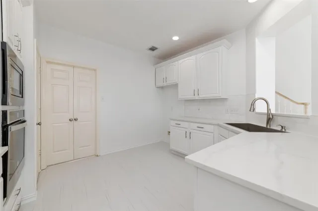 a kitchen with granite countertop a sink a stove and cabinets