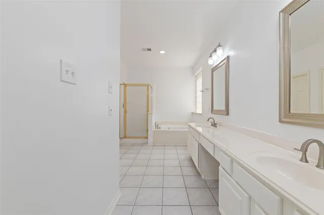 a bathroom with a double vanity sink a mirror and a bathtub