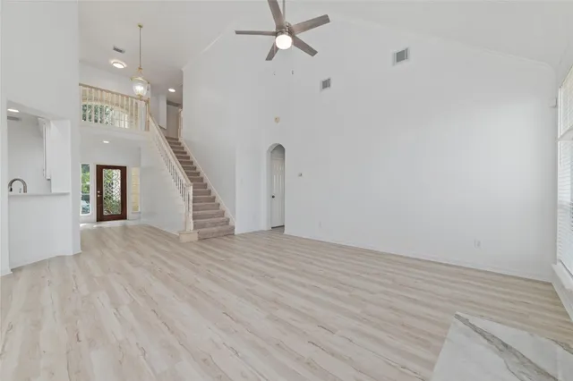 an empty room with wooden floor and staircase