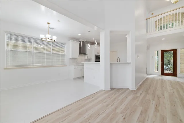 a view of a big room with wooden floor and windows
