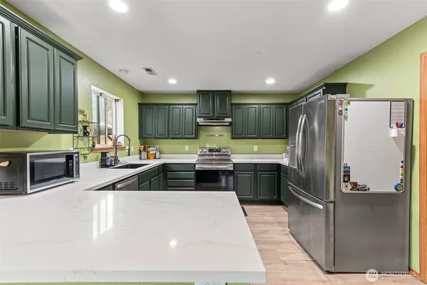 a kitchen with granite countertop a refrigerator and a sink