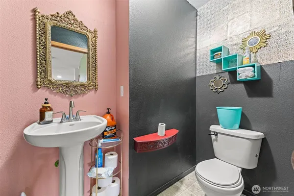 a bathroom with a toilet sink and mirror