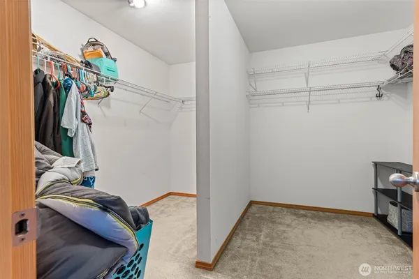 a view of walk in closet with clothes and shoes