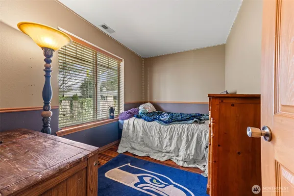 a bedroom with a bed and a mirror on dresser