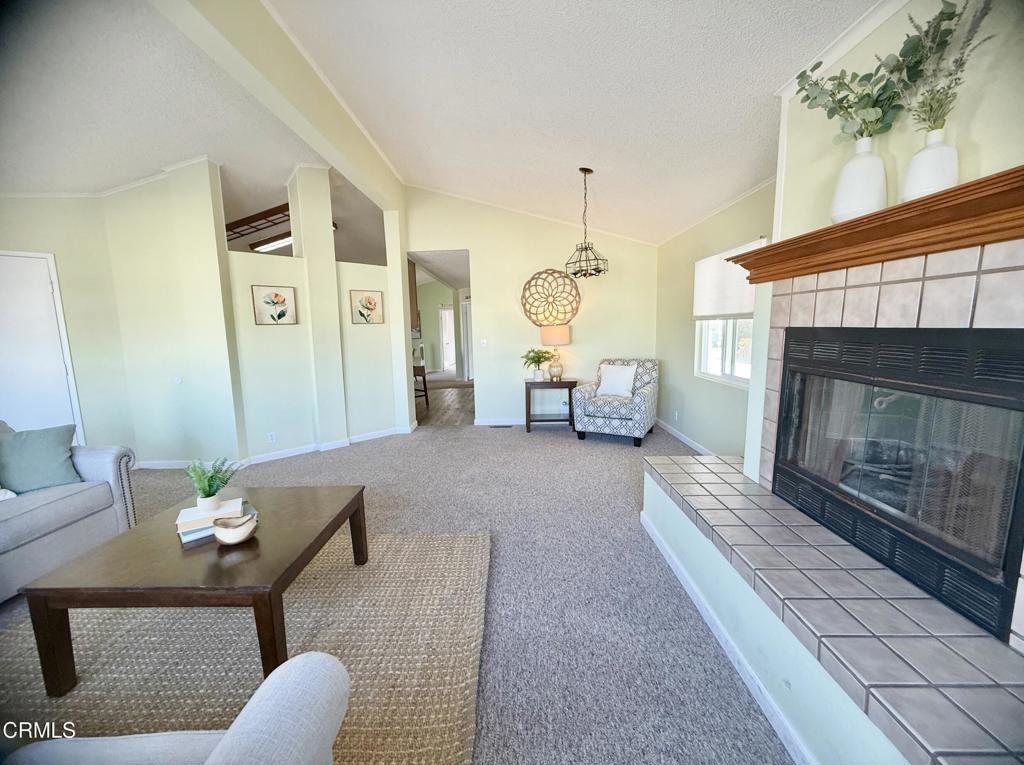 75 Copland Circle, Unit 75 Ventura, CA 93003 - Photo 3 of 22 a living room with furniture a fireplace and a chandelier