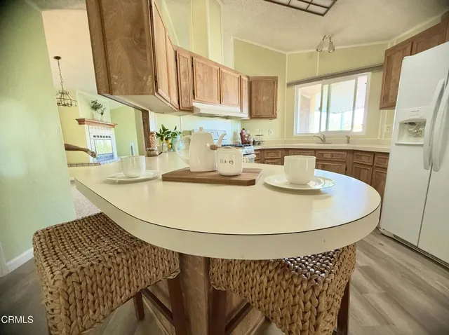 a kitchen with stainless steel appliances granite countertop a sink a microwave a refrigerator and cabinets