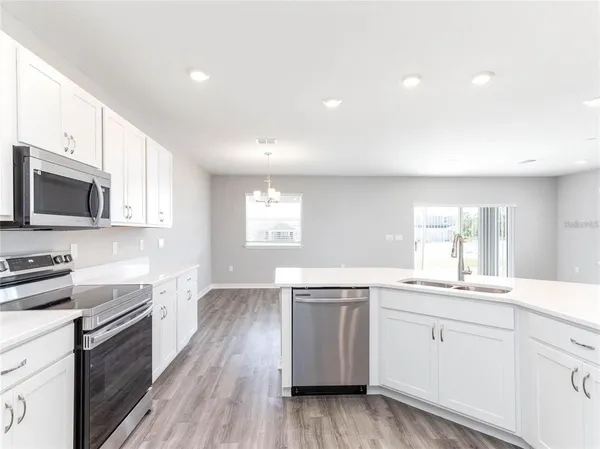 a kitchen with a sink stove and microwave