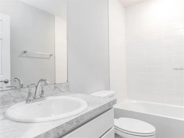 a bathroom with a granite countertop sink toilet and bathtub