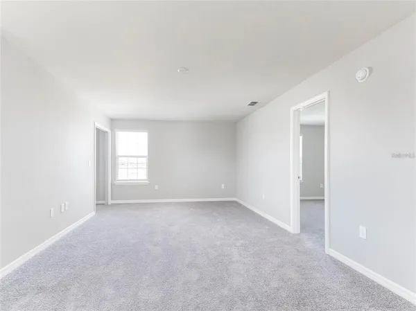 a view of an empty room with a window and closet area