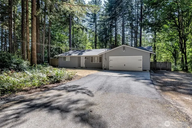 a view of a house with backyard and trees