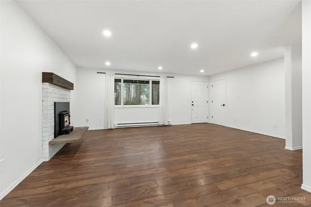 an empty room with wooden floor and a fireplace
