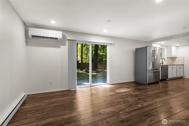 a view of a kitchen with wooden floor and stainless steel appliances