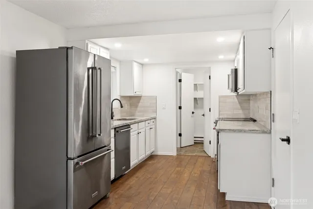a kitchen with stainless steel appliances granite countertop a refrigerator and a stove