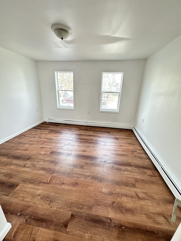 391 Pleasant Street Holyoke, MA 01040 - Photo 5 of 14 an empty room with wooden floor and windows