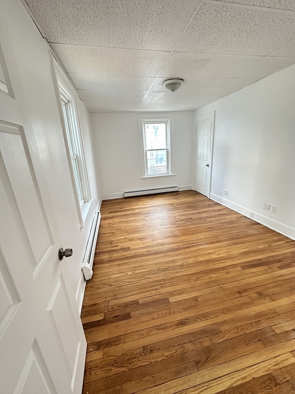 391 Pleasant Street Holyoke, MA 01040 - Photo 10 of 14 a view of an empty room with wooden floor and a window