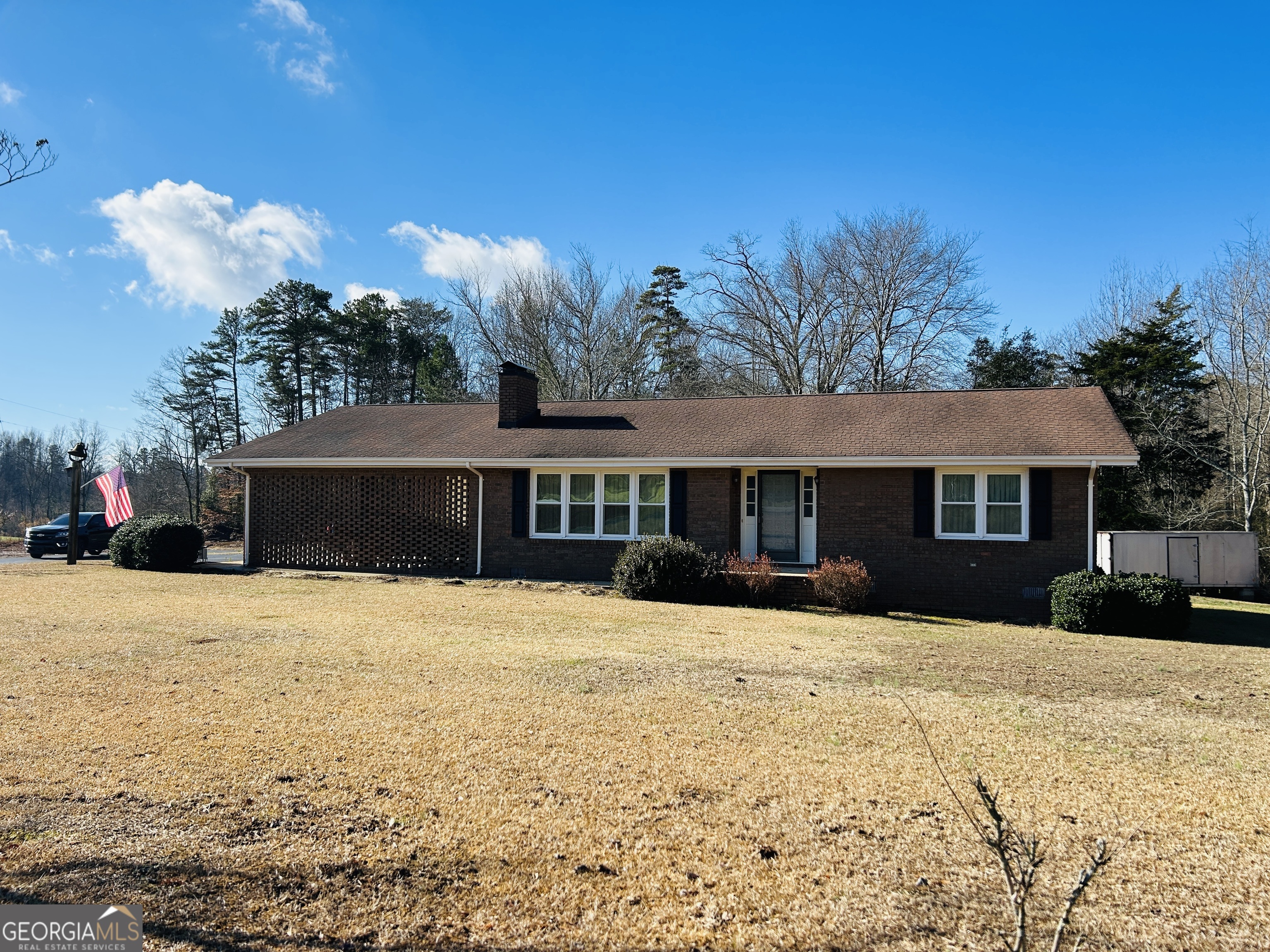 a front view of a house with a yard covered with snow