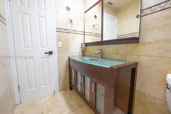a bathroom with a granite countertop sink and a mirror
