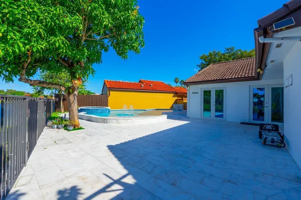 a view of a house with a backyard and a tree
