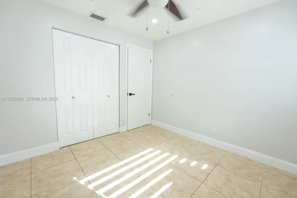 an empty room with a ceiling fan and carpet