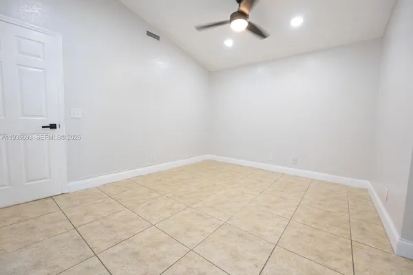 a view of an empty room with a fireplace and a window