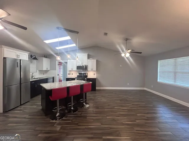 a large kitchen with a table chairs refrigerator and microwave