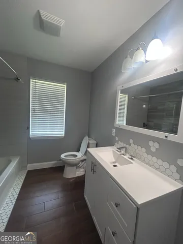a bathroom with a sink vanity and a toilet