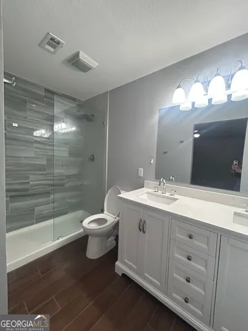a bathroom with a double vanity sink toilet and shower