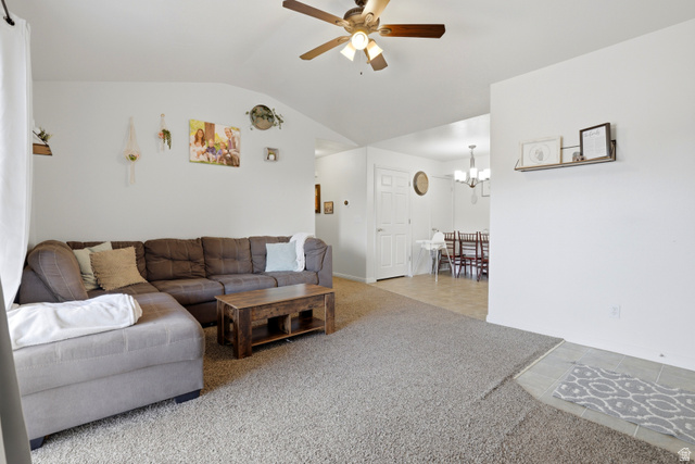 8083 North Ridge Loop East, Unit I 9 Eagle Mountain, UT 84005 - Photo 6 of 17 Living room with ceiling fan, light carpet, lofted ceiling, light tile patterned floors, and a chandelier
