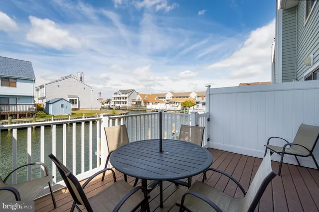 a view of a chairs and table on the roof deck