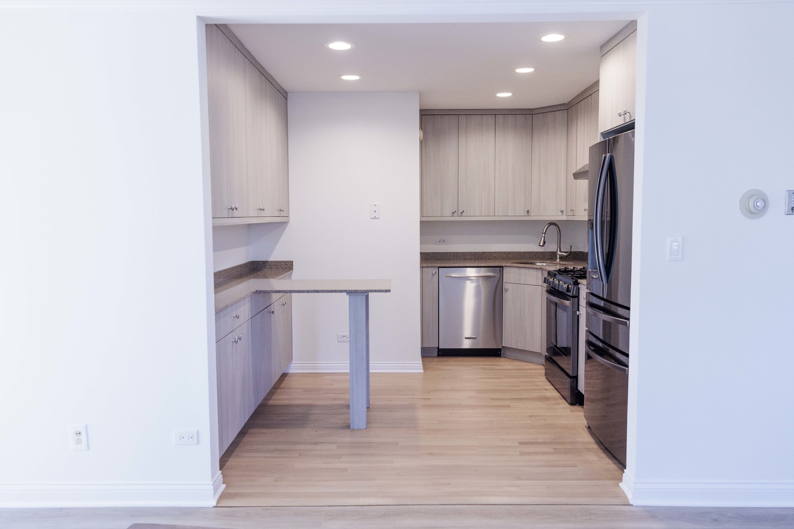 5 Echo Court, Unit 12 Vernon Hills, IL 60061 - Photo 4 of 14 a kitchen with kitchen island granite countertop a stove top oven and cabinets