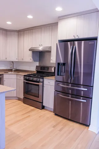 a kitchen with granite countertop stainless steel appliances and wooden cabinets
