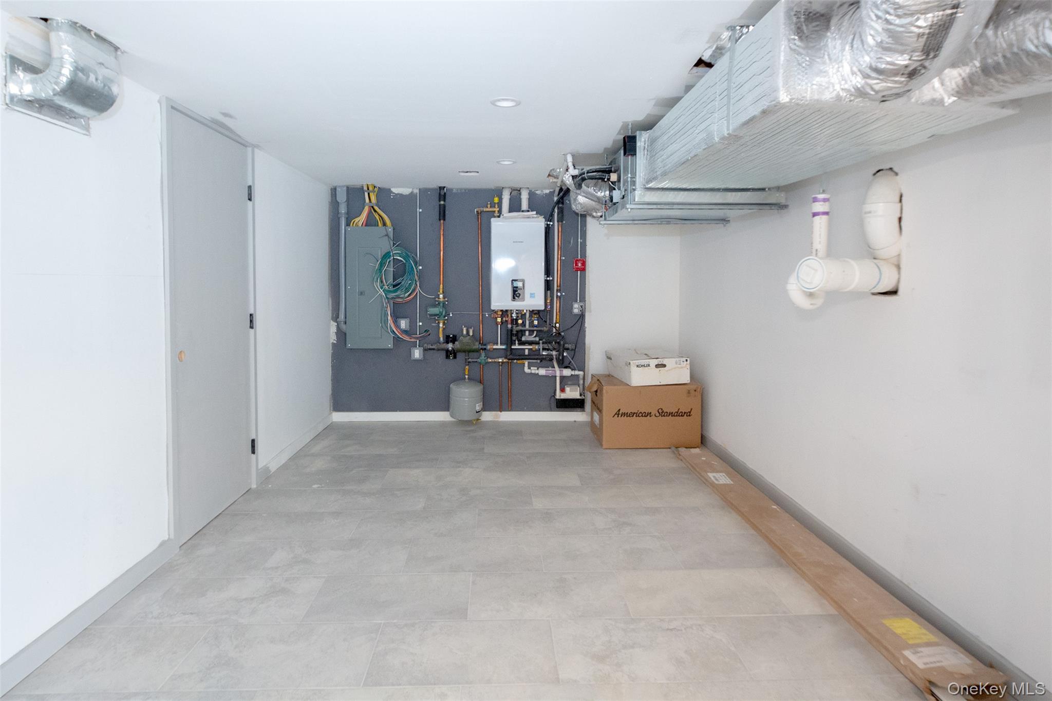 195 Little Fresh Pond Road Southampton, NY 11968 - Photo 35 of 40 Basement featuring electric panel and tankless water heater