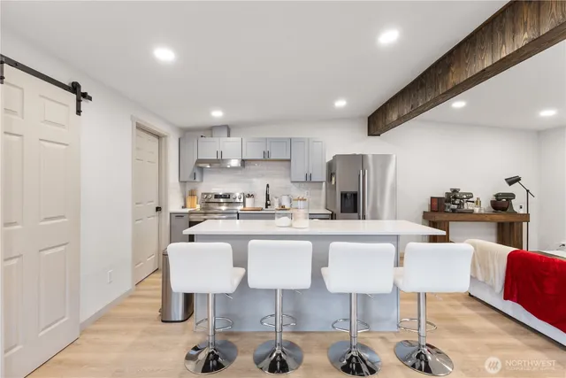 a kitchen with a dining table chairs refrigerator and sink
