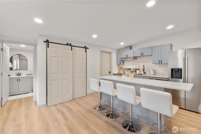 a kitchen with kitchen island a sink cabinets and stainless steel appliances