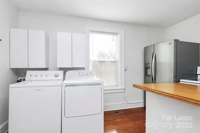 a view of a kitchen with refrigerator and window
