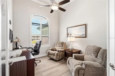 a living room with furniture two window and a flat screen tv