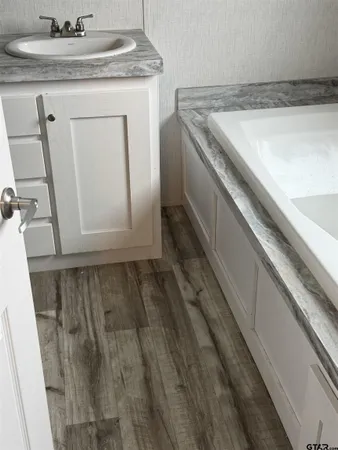 a bathroom with a granite countertop toilet and a sink