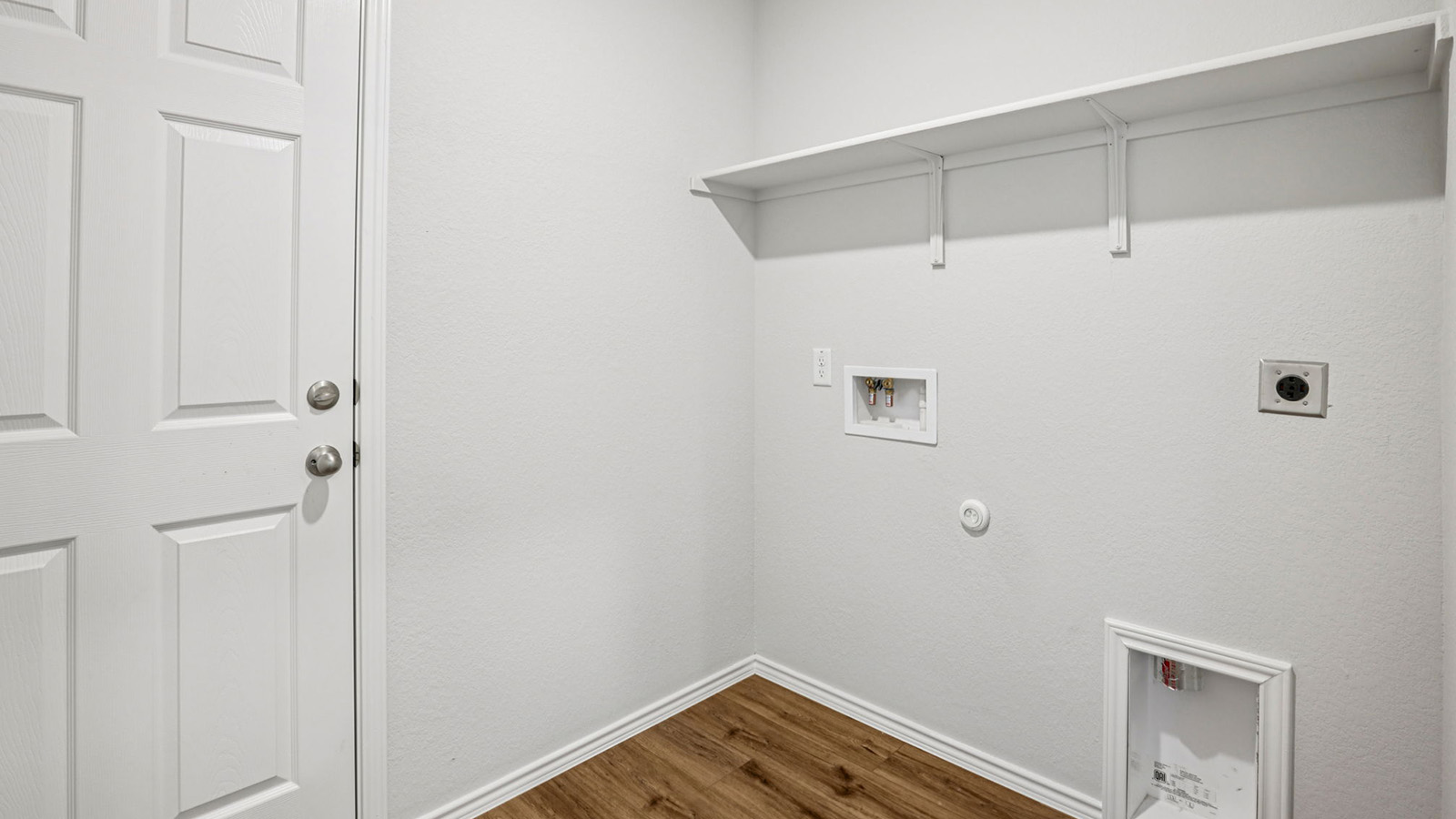 148 Wyatt Way Jarrell, TX 76537 - Photo 32 of 33 Dedicated laundry area featuring wood-finish flooring, white walls, and a built-in white shelf