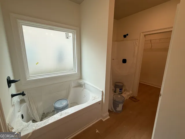 a bathroom with a tub sink and mirror
