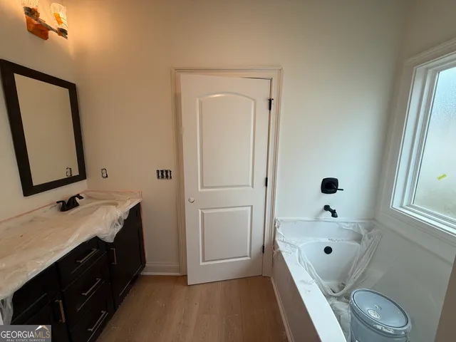 a bathroom with a tub sink and mirror