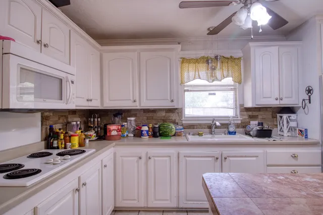 a kitchen with stainless steel appliances granite countertop a sink a stove and cabinets
